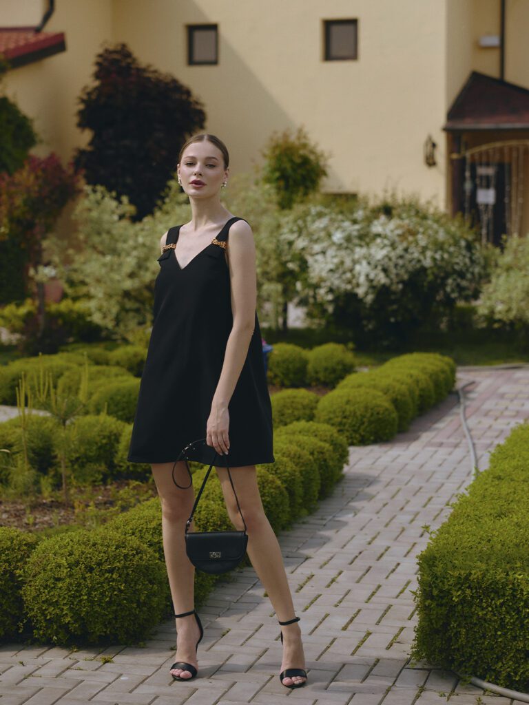 девушка в платье с черной сумкой