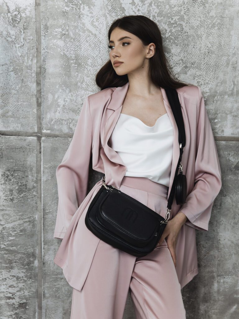 девушка в розовом костюме с черной сумкой