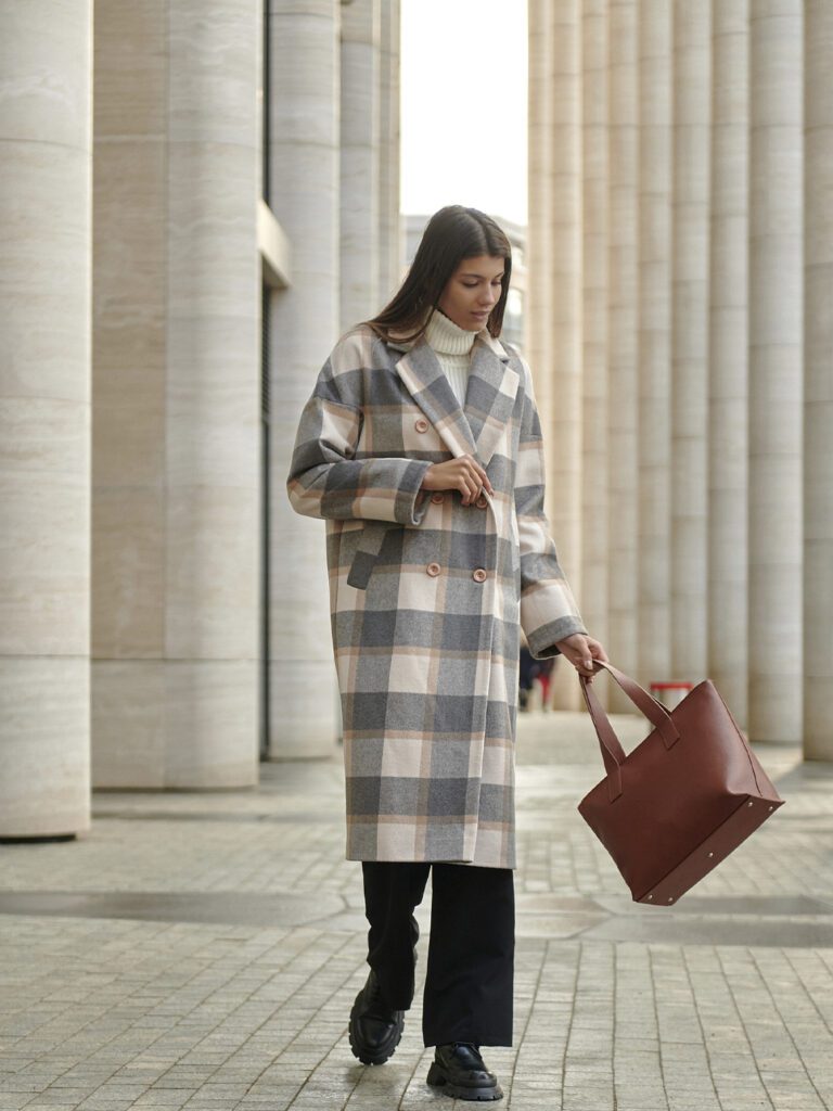 девушка в клетчатом пальто с сумкой