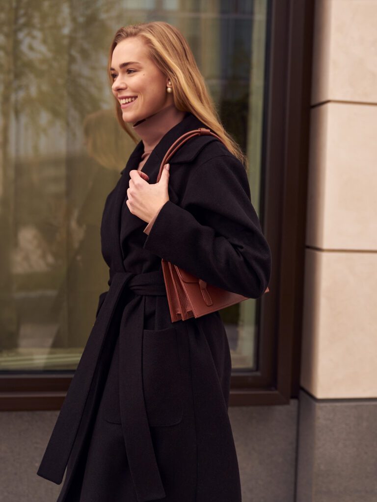 девушка в черном пальто с сумкой